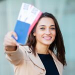 ragazze che mostra felice i biglietti aerei acquistati