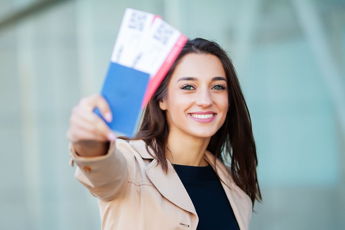 ragazze che mostra felice i biglietti aerei acquistati